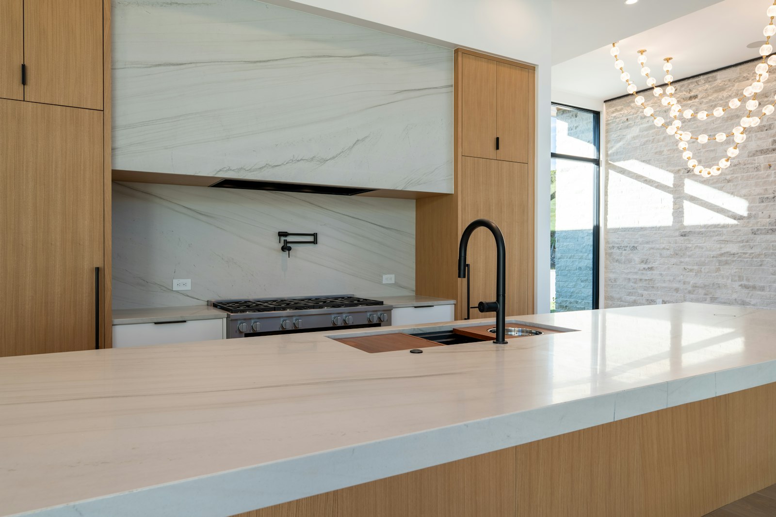Modern kitchen with wood cabinets and a marble-look stone backsplash